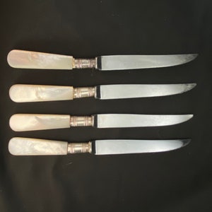 Four antique mother of pearl and stainless steal knives made in Sheffield, England.