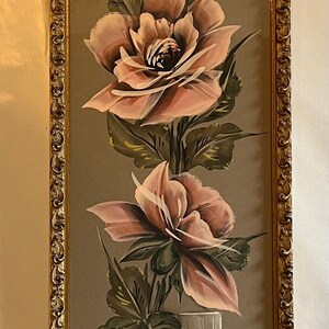 May include: A framed painting of pink roses in a clear glass vase with a brown background. The painting is signed "Tiney" in the bottom left corner.