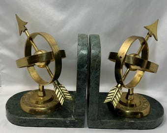 Vintage bookends feature brass armillary spheres set on green marble.