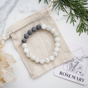 May include: A white and gray beaded bracelet with a small pouch and a card that says "the ROSEMARY Press".