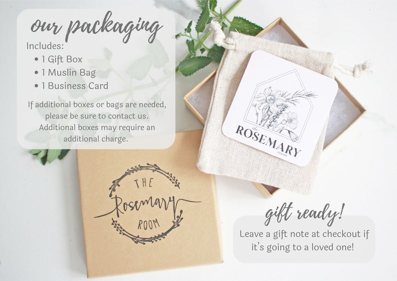 Puede incluir: Una caja de regalo marr&oacute;n con una etiqueta blanca que dice "The Rosemary Room". La caja est&aacute; llena de una bolsa de muselina blanca que contiene una tarjeta blanca con una ilustraci&oacute;n en blanco y negro de romero y el texto "Rosemary".