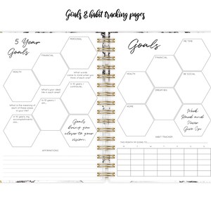 May include: A white planner with a marble pattern and gold accents. The planner has a section for 5-year goals with hexagonal shapes for different areas of life, such as health, financial, and personal. It also has a section for monthly goals and a habit tracker.