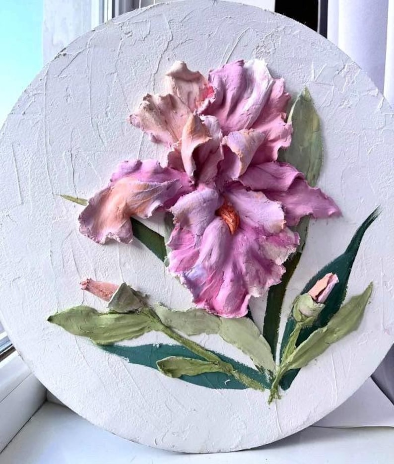 K&ouml;nnte beinhalten: Eine rosa und wei&szlig;e Iris-Blume mit gr&uuml;nen Bl&auml;ttern ist in 3D auf einer wei&szlig;en runden Leinwand modelliert.