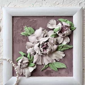 May include: A framed artwork featuring a 3D relief sculpture of white peonies with green leaves on a light brown background.