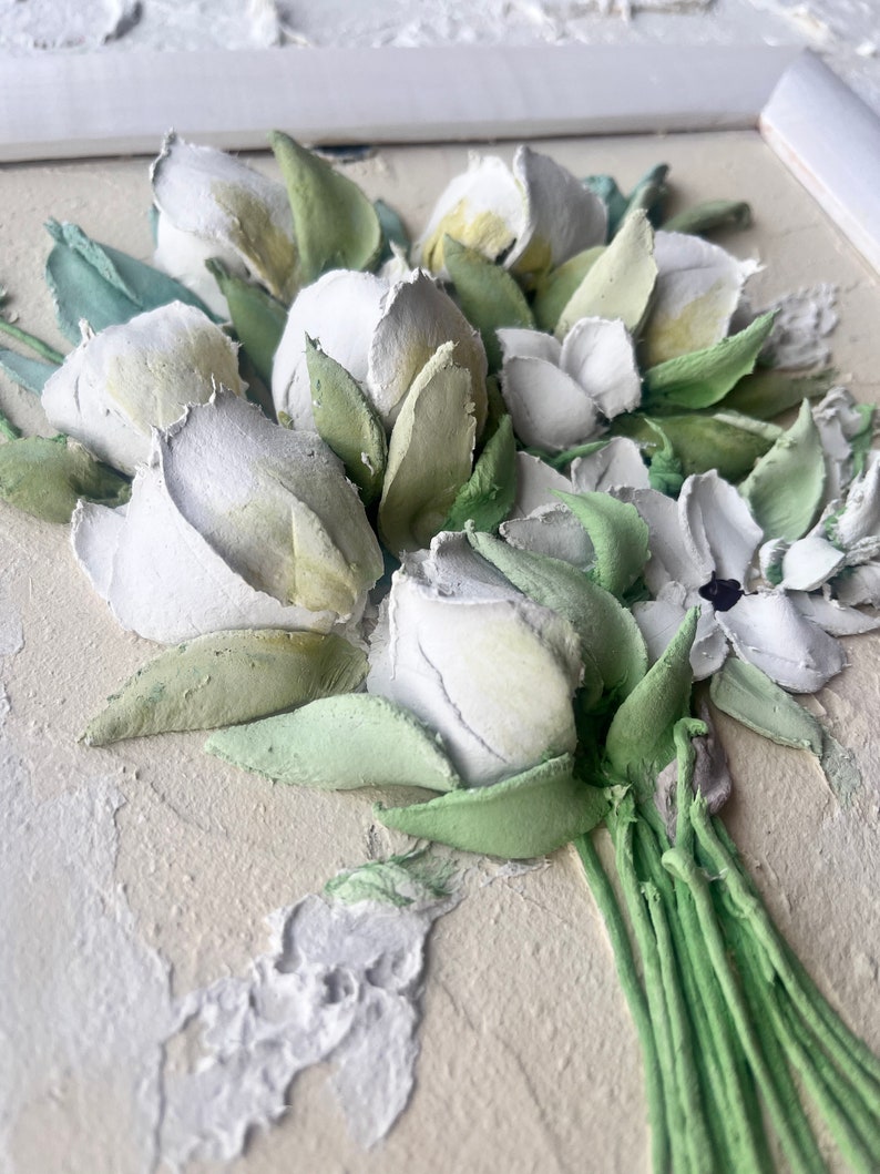 May include: A close-up of a white and green 3D floral painting. The flowers are arranged in a bouquet and have a textured, realistic look.