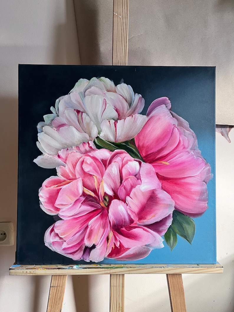 Puede incluir: Una pintura de peon&iacute;as rosas y blancas sobre un fondo azul oscuro. Las flores est&aacute;n dispuestas en un racimo y est&aacute;n en plena floraci&oacute;n. La pintura est&aacute; sobre un lienzo y est&aacute; en un caballete.
