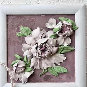 May include: A framed 3D art piece featuring a bouquet of white peonies with green leaves on a textured mauve background.