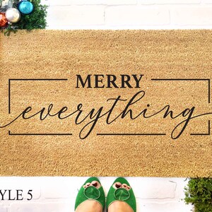 May include: A brown coir doormat with the text "MERRY everything" in a black rectangular frame.