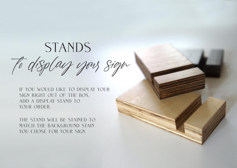 May include: Wooden display stands for signs. The stands are made of plywood and are stained to match the background stain of the sign. "STANDS To display your sign" is written on the white background.