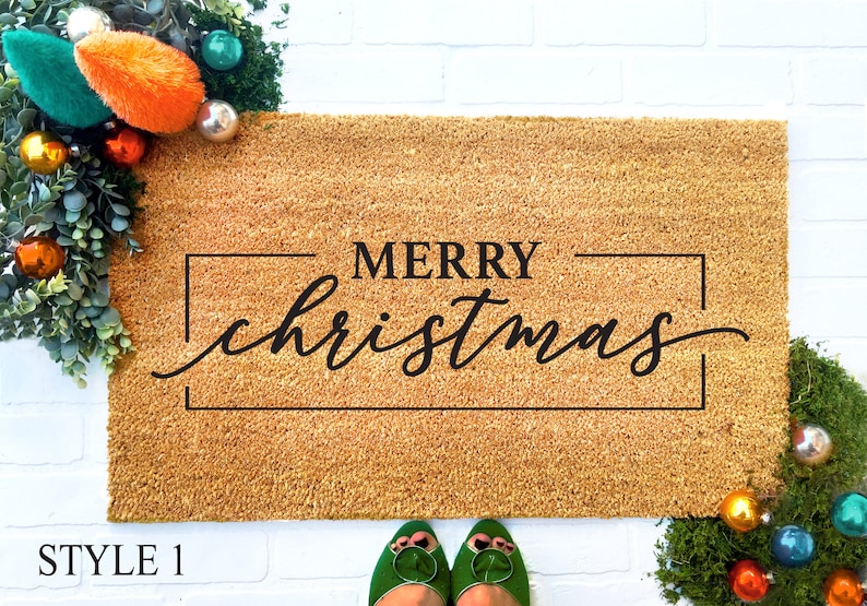 May include: A brown coir doormat with the text "MERRY christmas" in black lettering inside a black frame.