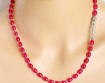 Collar asimétrico de ágata roja con forma de barril y detalles de perlas plateadas y grises.