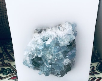 Crystal Candle~ White Chub Square Candle with an inlaid Blue Celestine Crystal Cluster that illuminates when lit! Burns for 200 hours