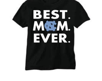 May include: Black t-shirt with white text that reads "BEST. MOM. EVER." with a blue North Carolina Tar Heels logo in the middle of the word "MOM".