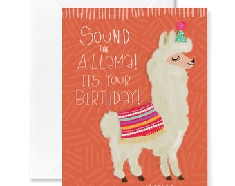Puede incluir: Una tarjeta de cumpleaños con una llama blanca que lleva un poncho de colores con estampado y un gorro de fiesta. El texto de la tarjeta dice "Sound the ALlama! It's your birthday!"