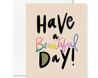 Könnte beinhalten: Eine Grußkarte mit einem pfirsichfarbenen Hintergrund und dem Text "Have a Beautiful Day!" in Schwarz, wobei das Wort "Beautiful" in Regenbogenfarben gehalten ist.