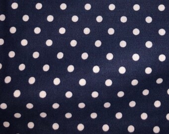 May include: Navy blue fabric with a repeating pattern of white polka dots. The dots are evenly spaced and create a classic, timeless design. This textile is suitable for various sewing and crafting projects.