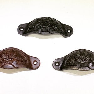 May include: Three cast iron drawer pulls with a decorative eagle design. The pulls are available in black, brown, and a dark gray finish.