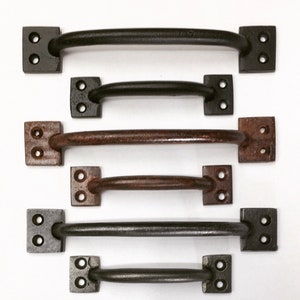 May include: Six black metal door pulls with square plates and rounded handles. The pulls are in various sizes.