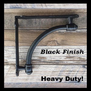 May include: Black metal shelf bracket with a curved arm and a decorative finial. The bracket is heavy duty and has a black finish.