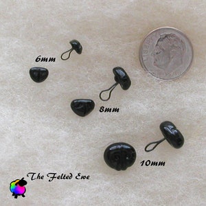 May include: Four black plastic safety eyes with a loop for sewing. The eyes are 6mm, 8mm, and 10mm in diameter. The eyes are on a white fuzzy surface.