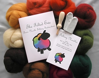 May include: A felting kit with ten balls of wool in various colors, including brown, red, orange, green, and cream. The kit also includes two felting needles, two finger guards, and instructions for basic needle felting. The text on the instructions reads "The Felted Ewe Basic Needle Felting Instructions". The text on the needle card reads "Felting Needles Sizes 367, 365, 367, 385, 40T & 42T All you need to create any Needle Felting Masterpiece!"