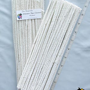 May include: A pack of white pipe cleaners, also known as chenille stems, with a label that reads "The Felted Ewe Amigurumi Pipe Cleaners 50 Pieces".