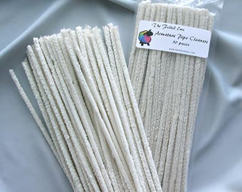 May include: A bag of white pipe cleaners for cleaning pipes. The bag is labeled "The Fiber Co. Artisan Pipe Cleaners 50 pack".
