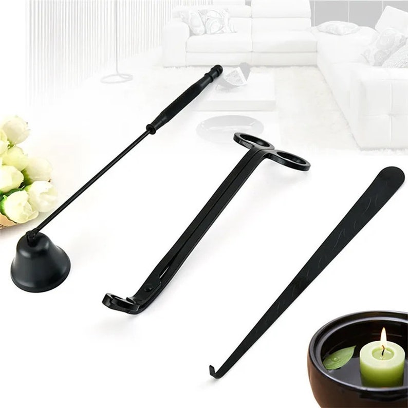 May include: A set of three black candle care tools. The tools include a candle snuffer, a wick trimmer, and a wick dipper. The tools are made of metal and have a black finish.