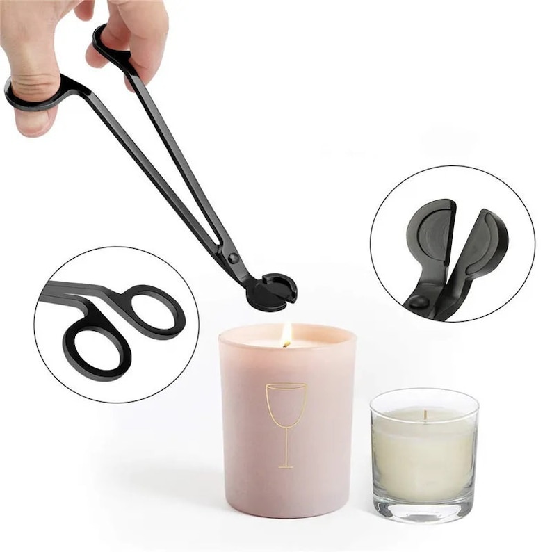 May include: Black metal candle wick trimmer with a long handle. The trimmer is being used to trim the wick of a pink candle. A second candle is shown in a glass jar.