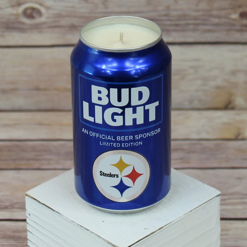 May include: A blue and white Bud Light beer can candle with the Pittsburgh Steelers logo and the text "An Official Beer Sponsor Limited Edition".