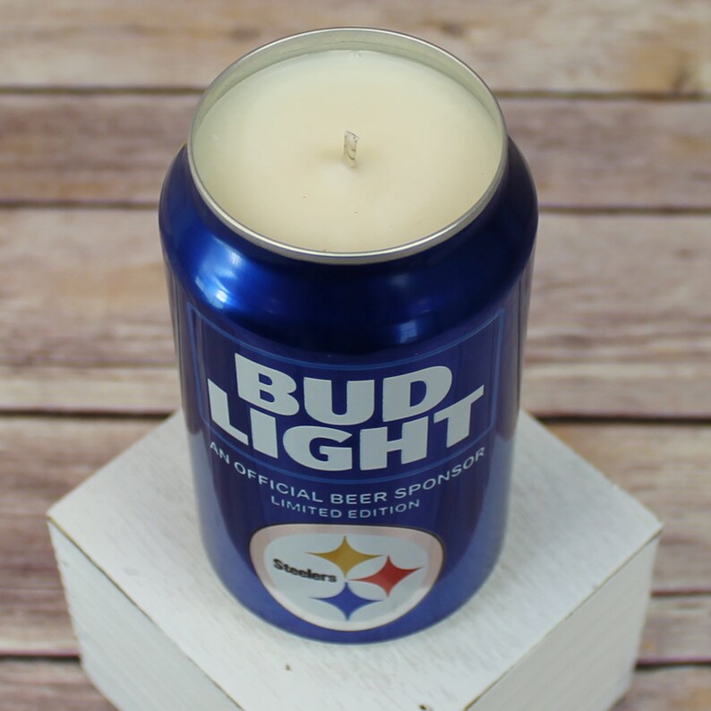 May include: A blue and white Bud Light can candle with the text "An Official Beer Sponsor Limited Edition" and the Pittsburgh Steelers logo.