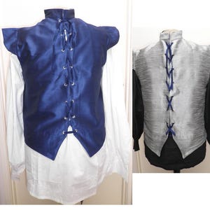May include: Two vests are shown, one navy blue and one silver. Both have a high collar and a laced back. The navy vest is on the left, the silver on the right. They are sleeveless and made of a shiny material.