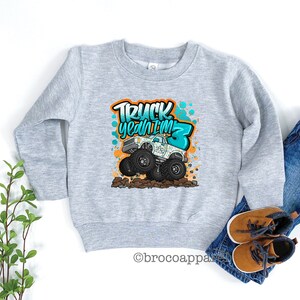 May include: Gray sweatshirt with a graphic of a monster truck and the text "Truck yeah I'm 3".