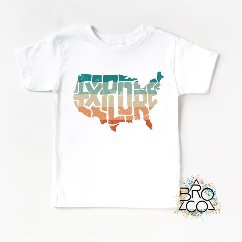 May include: A white short-sleeve t-shirt featuring a graphic of the contiguous United States map filled with the word EXPLORE in a distressed, multi-colored horizontal striped pattern of teal, beige, and orange. A logo reads BRO CO.