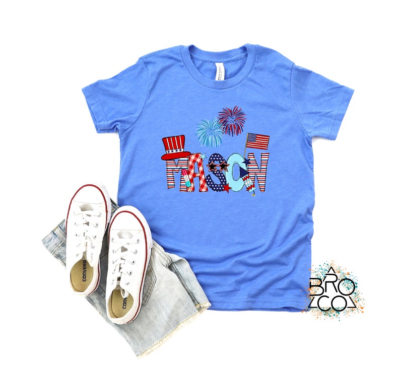 May include: A blue t-shirt with a red, white, and blue design featuring the name "MASON" in large letters. The letters are decorated with stars, stripes, and fireworks.