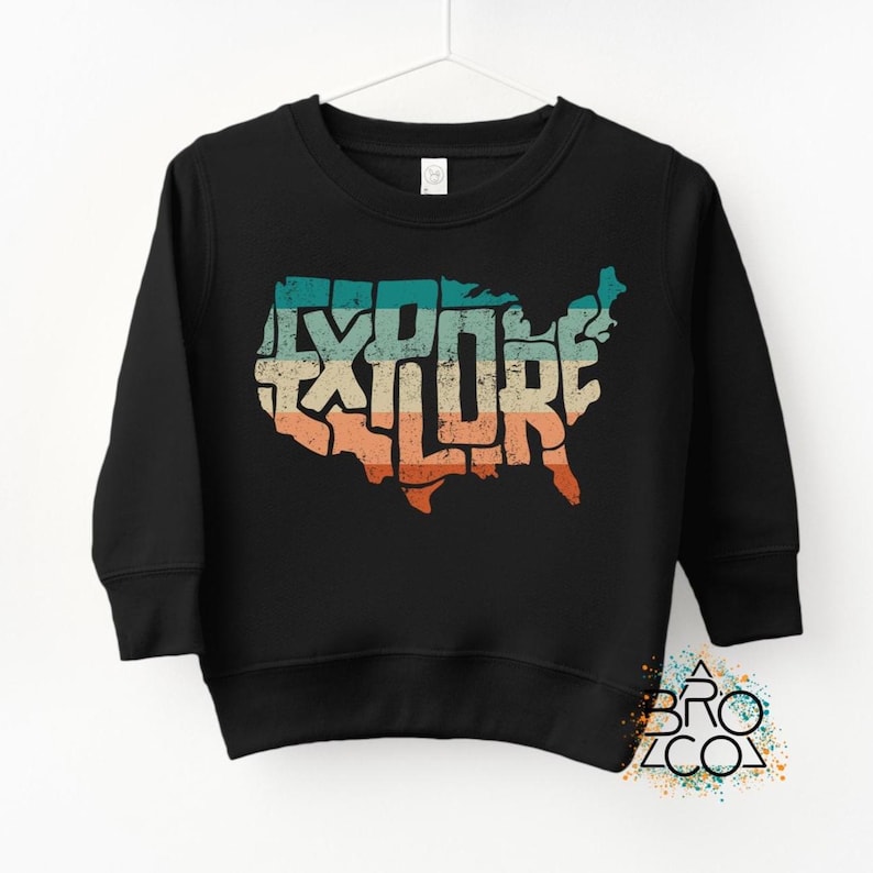 May include: A black long-sleeve sweatshirt featuring a graphic of the United States map filled with the word EXPLORE in a distressed, multi-colored horizontal striped pattern of teal, cream, and orange tones on the front.