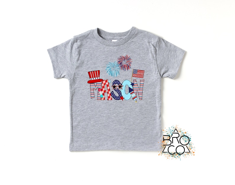 May include: A gray t-shirt with a red, white, and blue design that says "MASON" with fireworks and American flags.