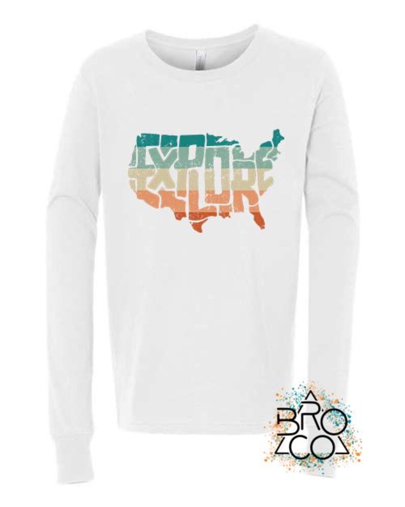 May include: A white long-sleeve shirt featuring a graphic of the United States map filled with the word EXPLORE in a distressed, horizontal striped pattern of teal, beige, and orange. A logo with the text BRO CO is in the bottom corner.