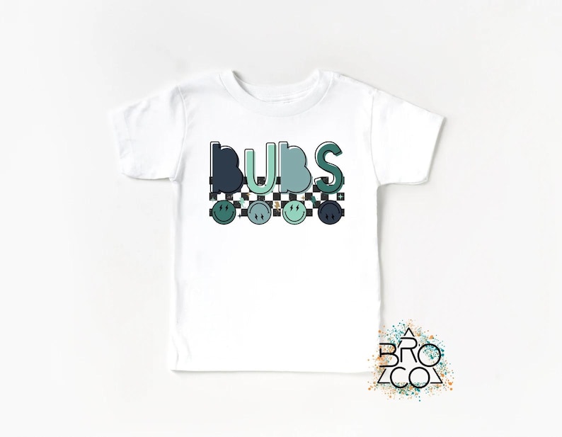 May include: White t-shirt with the word "BUBS" in green and blue letters with a checkered pattern and smiley faces.