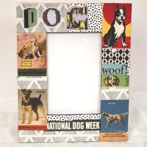 May include: Rectangular picture frame with the word "DOG" at the top. The frame is decorated with images of different dog breeds, including a Chihuahua, Terrier, and Setter. The phrase "NATIONAL DOG WEEK" is printed at the bottom.