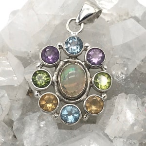 May include: A silver pendant with an opal gemstone surrounded by smaller gemstones in shades of purple, green, blue, and yellow.