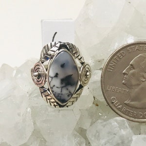 Pu&ograve; includere: Un anello d'argento con una pietra di agata bianca e nera incastonata in un design d'argento dettagliato. L'anello &egrave; circondato da cristalli bianchi.