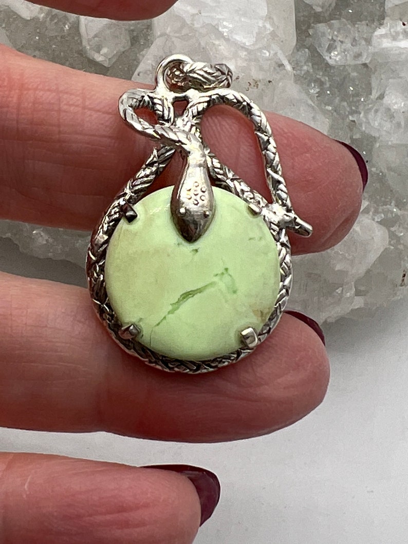 May include: A silver pendant featuring a green serpentine stone set in a silver snake design.