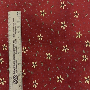 May include: Red fabric with a white floral pattern. The fabric has a subtle texture and a scattered pattern of small white dots.