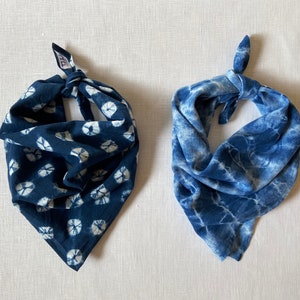 May include: Two blue cotton bandanas with tie-dye patterns. One bandana has a white and blue circular pattern, the other has a white and blue marbled pattern.