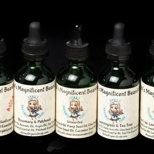 May include: Five small green glass bottles with dropper tops, each labeled "Anna's Organic Soap" and containing beard oil with different scents: Sweet Almond Oil, Sunflower Oil, Avocado Oil, Peppermint Essential Oil, Rosemary & Patchouli, Unscented, Hemp Seed Oil, Chia Seed Oil, Cucumber Seed Oil, Lemongrass & Tea Tree, Tea Tree Essential Oil, Chia Seed Oil, Lavender & Sandalwood, Lavender Essential Oil, Avocado Oil, Sweet Almond Oil.