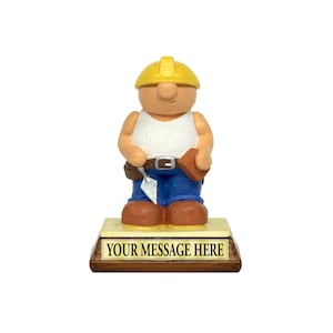 May include: A figurine of a construction worker wearing a yellow hard hat, white vest, blue jeans, and brown work boots. The figurine holds a trowel and a brick. The base has a gold plaque that reads "YOUR MESSAGE HERE".