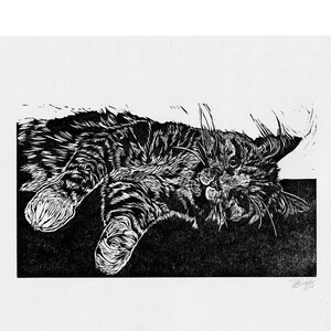 Puede incluir: Grabado en lin&oacute;leo en blanco y negro de un gato acostado de espaldas con las patas en el aire. El gato tiene una expresi&oacute;n de sorpresa en su rostro.