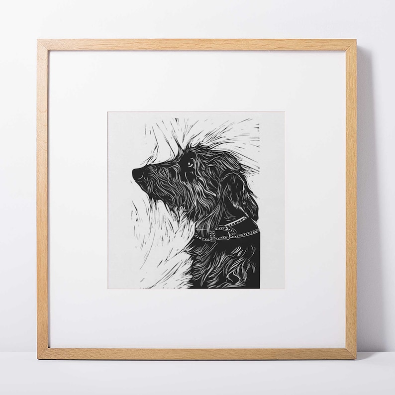 May include: Black and white linocut print of a dog with a collar, looking up and to the left. The dog's fur is detailed with lines and the background is a white textured surface.