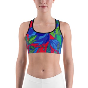 May include: A red sports bra with a colourful floral pattern featuring blue, green, and red leaves. The bra has a black racerback design.
